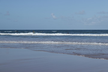 surfer in the middle of the waves on the beach