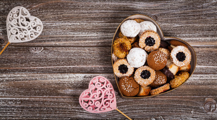 Fototapeta na wymiar Valentines Day Card Background with Assorted Cookies over Wooden Background. Selective focus.