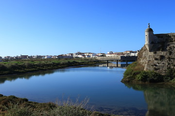 detail of ancient fortification in the city of Peniche in Portugal lined with water and its reflections