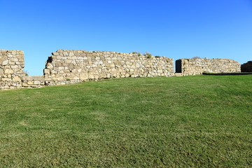 grassy lawn with ruins in the background