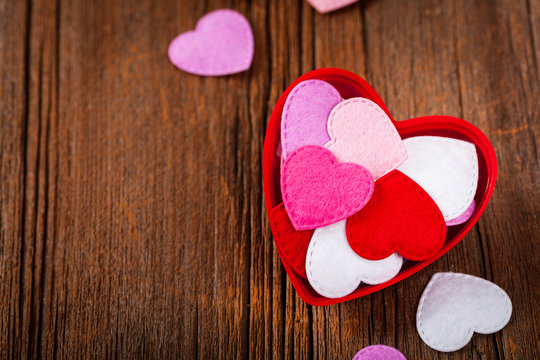 Valentines Day Background Card with Fabric Hearts over Wooden Background. Selective focus.