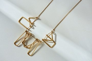 elevated view of beautiful luxury necklace on white surface with sunlight