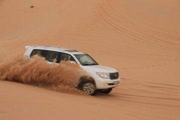Fototapeta na wymiar rasante Dünenfahrt in der Wüste in Abu Dhabi mit einem Jeep