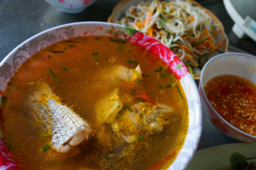 Delicious fish soup with onion tomato chillies sauce herbs pineapple traditional Vietnamese food 