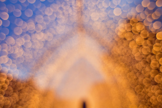 Christmas lights forming a tunnel. Blurred photograph of warm fairy lights, lanterns creating a tunnel in the city's Botanic garden in winter.