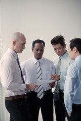 Fototapeta premium Serious multi-ethnic business team reading new substantial order of authority