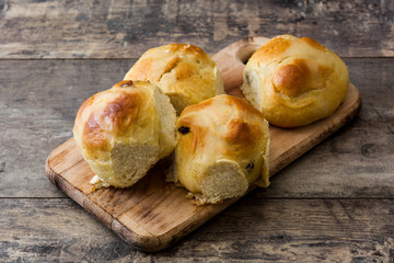 Traditional Easter hot cross buns on wooden table. 