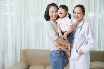 Fototapeta premium Joyful little Vietnamese girl, her mother and pediatrician