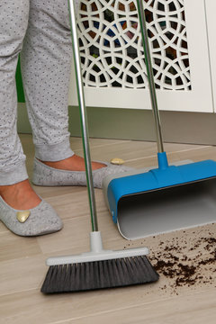 brush and dustpan cleaning floor