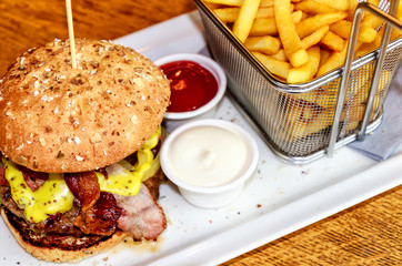 Honey-Mustard-Burger with French Fries in a small net basket