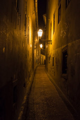 Fototapeta na wymiar Narrow Pathway Between Buildings at Night
