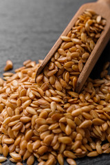 seeds of golden flax on a dark stone background