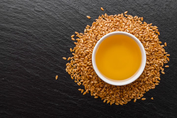 seeds of golden flax on a dark stone background