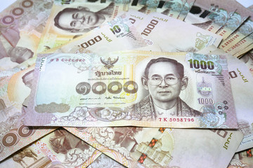 One thousand baht banknotes put on the isolated white background that represent the King Rama IX and the most value of banknote of Thailand.