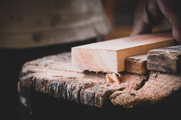 Carpenter working on woodworking machines in carpentry shop