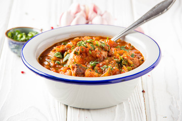 Chicken in tomato sauce with herbs and onions, cilantro parsley mint, traditional Oriental dish chakhokhbili, delicious homemade food.