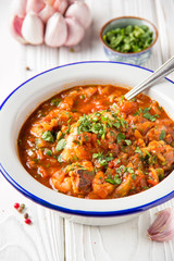 Chicken in tomato sauce with herbs and onions, cilantro parsley mint, traditional Oriental dish chakhokhbili, delicious homemade food.