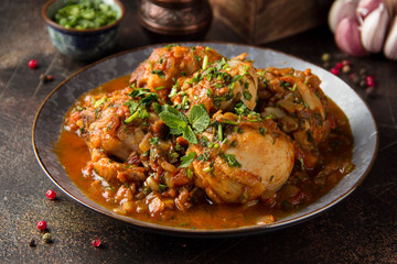 Chicken in tomato sauce with herbs and onions, cilantro parsley mint, traditional Oriental dish chakhokhbili, delicious homemade food