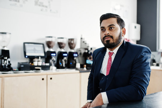 Stylish beard indian business man on suit sitting at cafe.
