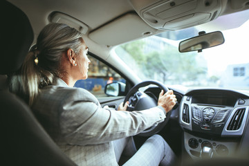 Senior businesswoman driving a car