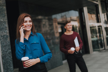 Successful lady talking by mobile phone on street