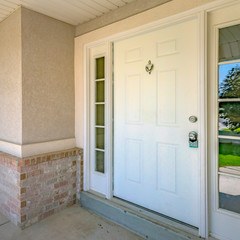 Fototapeta na wymiar White front door with door knocker and glass panes