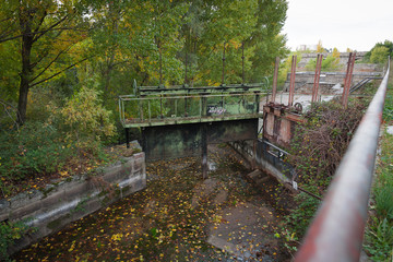 Old dam gates with remnants of tree leaves.