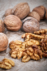 Walnut kernels with whole nuts in background, selective focus.