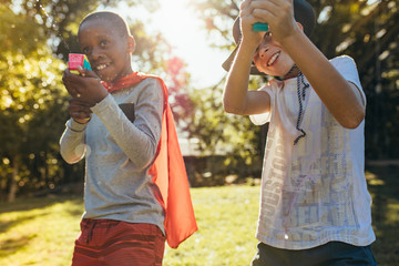Obraz premium Kids playing with squirt guns outdoors