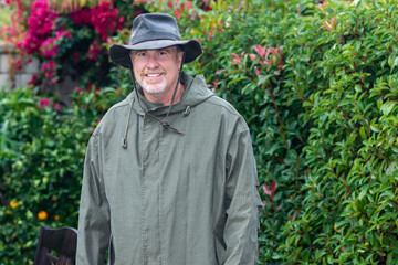 Portrait of happy senior man in rain storm