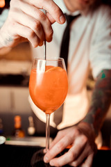 An orange cocktail is on the table in a cafe / restaurant. Bar. Orange cocktail on the table a cozy cafe, with a copy space for text. Alcoholic drink based on a table with ice and oranges.