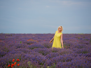 Young girl in yellow dress, posing in a lavender field.