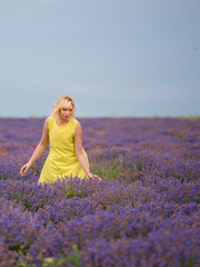 Young girl in yellow dress, posing in a lavender field.