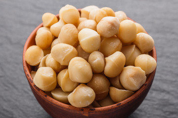 delicious macadamia nuts on a dark stone background
