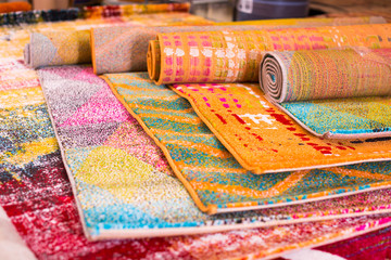 Various colorful wool rugs for sale at store
