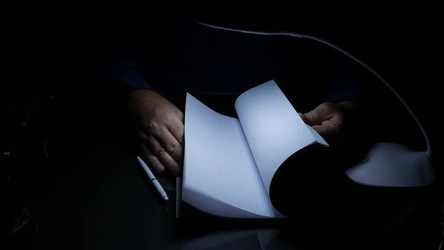 Businessperson in Dark Room Browse Register Pages Looking for Information