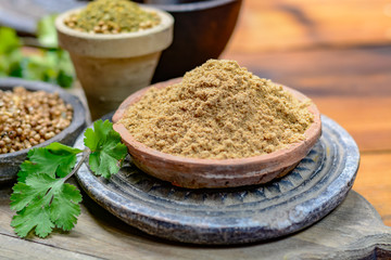 Clay bowls wirh dried coriander seeds and coriander powder close up, spices collection