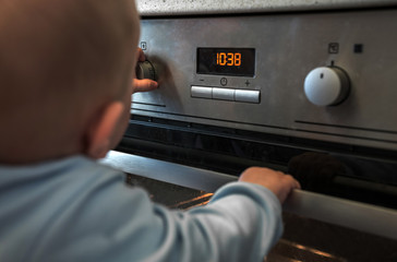 child in danger playing with an electric  in the kitchen.
