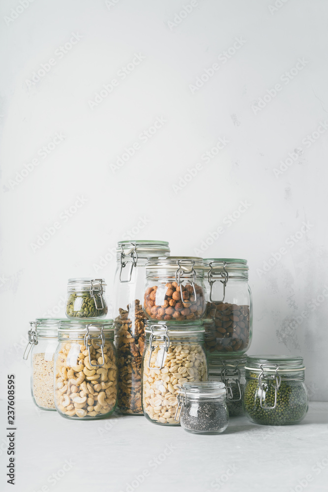 Wall mural Glass jars with Superfoods nuts and cereals stacked on top of each other