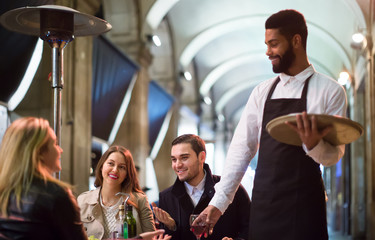 Afro waiter taking table order and smiling