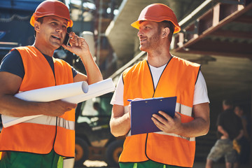 Workers in helmets are locating on project