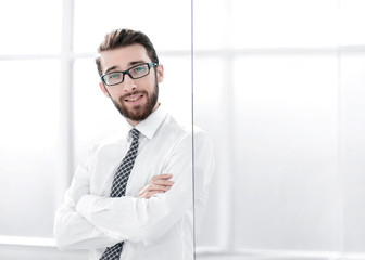 confident businessman standing near the office window