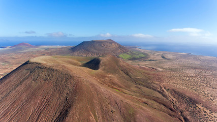 Fototapeta premium Panorama over volcanic mountains in Lanzarote, Canary Islands, Spain, aerial view .
