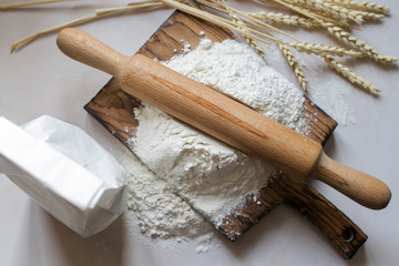 White flour for baking. Fine grinding, kitchen table, rolling pin, package. Recipe for traditional bread.