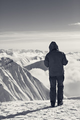 Fototapeta na wymiar Skier on top of snowy mountains in clouds