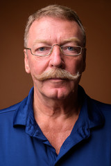 Obraz premium Face of senior man with mustache wearing eyeglasses