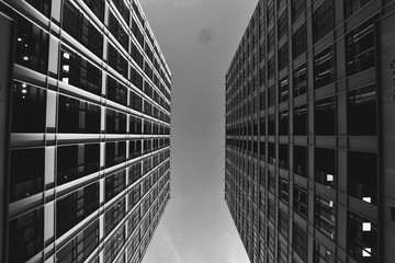 Low angle view two building against cloudy sky, symmetry