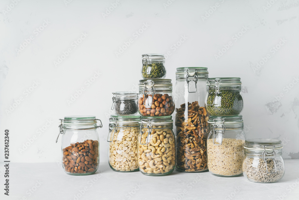 Wall mural Glass jars with Superfoods nuts and cereals stacked on top of each other - Wall murals