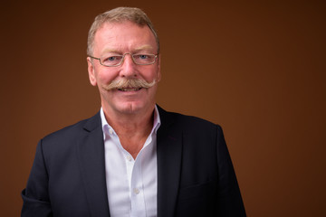 Happy senior businessman with mustache wearing suit