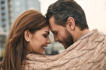 Lovely couple with plaid is standing outdoor